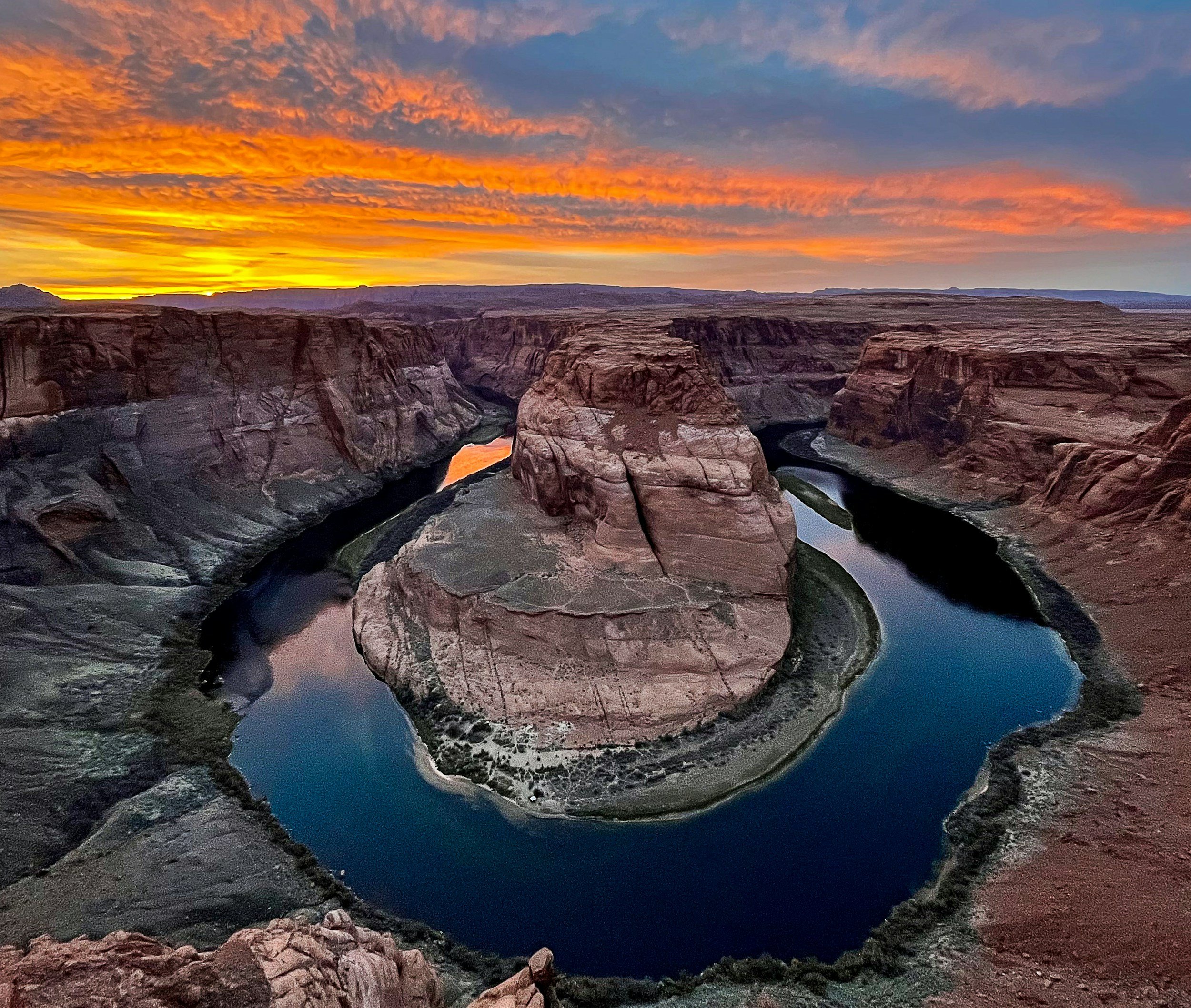 Scenic view of Horseshoe Bend, Arizona, with Colorado River and vibrant sunset sky.